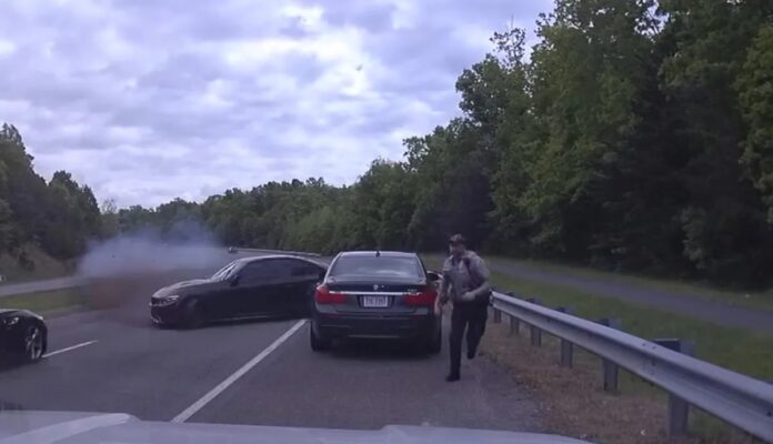 A wild crash in the US saw an out-of-control car almost hit an officer A wild crash in the US saw an out-of-control car almost hit an officer